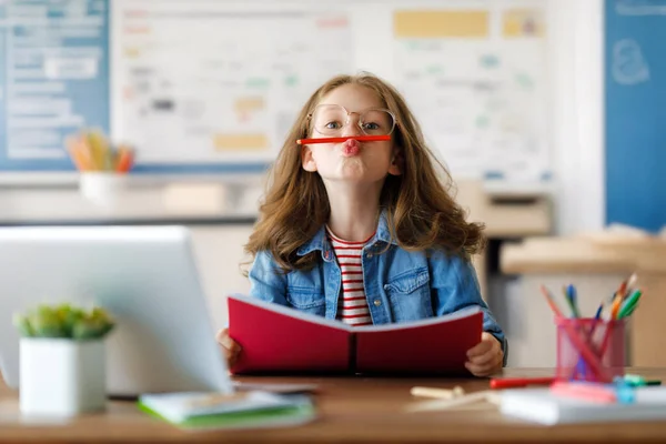 学校に戻る 幸せな子供が机に座っている 宿題やオンライン教育をする女の子 — ストック写真