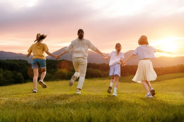 夕阳西下的快乐家庭妈妈和孩子们都在跑步 玩得很开心 也很享受夏天的夜晚 — 图库照片