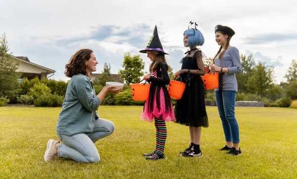 Szczęśliwi Ludzie Świętują Halloween Dorosły Leczy Słodyczami Dzieci Świeżym Powietrzu — Zdjęcie stockowe