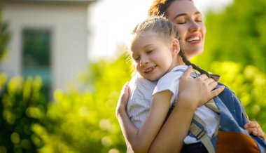 Ebeveyn ve çocuk okula gidiyor. Sırt çantalı kadın ve kız. Dersler başlıyor..