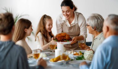 Şükran Günü, Sonbahar ziyafeti. Masada oturup bayramı kutlayan mutlu bir aile. Büyükbaba, anne, baba ve çocuklar. Geleneksel yemek..