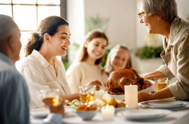 Şükran Günü, Sonbahar ziyafeti. Masada oturup bayramı kutlayan mutlu bir aile. Büyükanne ve büyükbaba, anne ve çocuklar. Geleneksel yemek..
