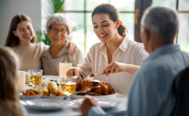 Şükran Günü, Sonbahar ziyafeti. Masada oturup bayramı kutlayan mutlu bir aile. Büyükanne ve büyükbaba, anne ve çocuklar. Geleneksel yemek..