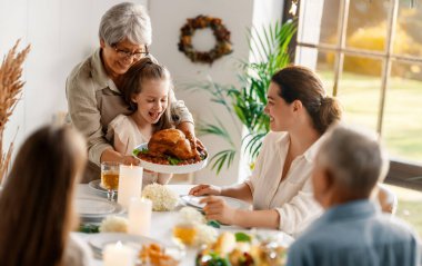 Şükran Günü, Sonbahar ziyafeti. Masada oturup bayramı kutlayan mutlu bir aile. Büyükanne ve büyükbaba, anne ve çocuklar. Geleneksel yemek..