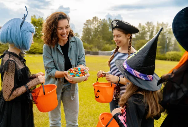 Счастливые Люди Празднуют Хэллоуин Взрослые Угощают Сладостями Детей Открытом Воздухе — стоковое фото