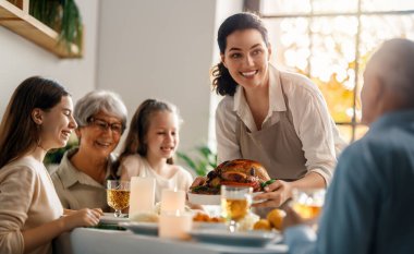 Şükran Günü, Sonbahar ziyafeti. Masada oturup bayramı kutlayan mutlu bir aile. Büyükanne ve büyükbaba, anne ve çocuklar. Geleneksel yemek..