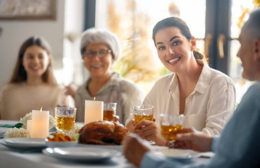 Şükran Günü, Sonbahar ziyafeti. Masada oturup bayramı kutlayan mutlu bir aile. Büyükanne ve büyükbaba, anne ve çocuklar. Geleneksel yemek..
