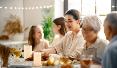 Şükran Günü, Sonbahar ziyafeti. Masada oturup bayramı kutlayan mutlu bir aile. Büyükanne ve büyükbaba, anne ve çocuklar. Geleneksel yemek..