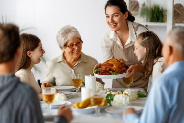 Şükran Günü, Sonbahar ziyafeti. Masada oturup bayramı kutlayan mutlu bir aile. Büyükbaba, anne, baba ve çocuklar. Geleneksel yemek..