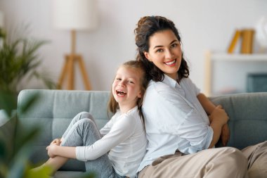 Anneler Günün kutlu olsun! Anne ve kızı oynuyorlar, gülümsüyorlar ve sarılıyorlar. Aile tatili ve birliktelik.