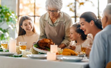 Şükran Günü, Sonbahar ziyafeti. Masada oturup bayramı kutlayan mutlu bir aile. Büyükanne ve büyükbaba, anne ve çocuklar. Geleneksel yemek..