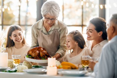 Şükran Günü, Sonbahar ziyafeti. Masada oturup bayramı kutlayan mutlu bir aile. Büyükanne ve büyükbaba, anne ve çocuklar. Geleneksel yemek..