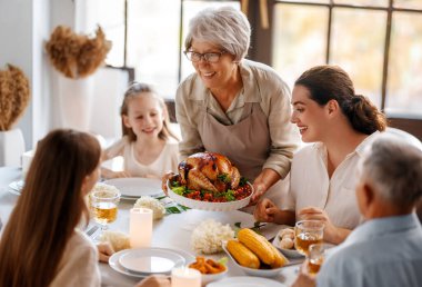 Şükran Günü, Sonbahar ziyafeti. Masada oturup bayramı kutlayan mutlu bir aile. Büyükanne ve büyükbaba, anne ve çocuklar. Geleneksel yemek..