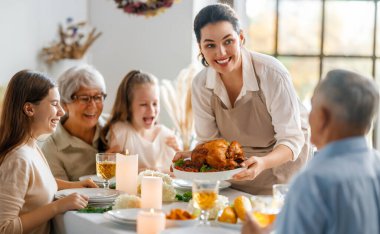Şükran Günü, Sonbahar ziyafeti. Masada oturup bayramı kutlayan mutlu bir aile. Büyükanne ve büyükbaba, anne ve çocuklar. Geleneksel yemek..