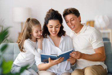 Mutlu ve sevgi dolu bir aile. Güzel genç anne kızına kitap okuyor..  