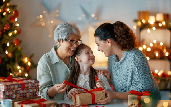 행복한 쾌활한 할머니 어머니와 귀여운 크리스마스 사람들은 선물을 감싸고 꾸미죠 — 스톡 사진