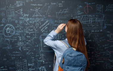 Okula dönelim. Mutlu şirin, çalışkan genç kapalı mekanda. Kız sınıfta tahtada öğreniyor.. 