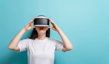 Metaverse teknoloji konsepti. Açık mavi duvar arka planında sanal gerçeklik gözlüklü kadın. Gelecekçi yaşam tarzı.