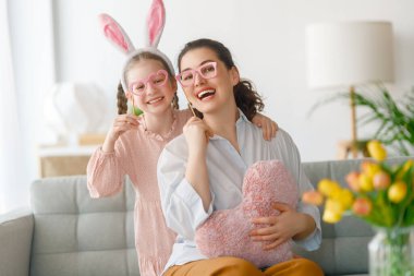 İyi tatiller. Anne ve kızı. Paskalyayı kutlayan aile. Sevimli küçük kız tavşan kulağı takıyor.. 