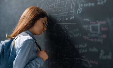 Okula dönelim. Evdeki mutsuz genç. Kız sınıfta tahtada öğreniyor..