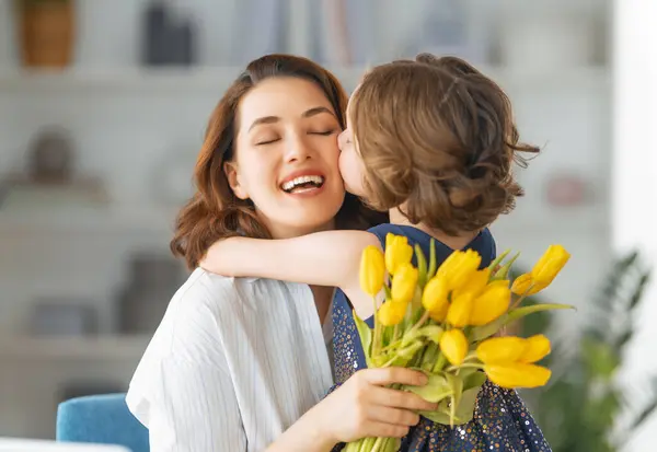 ハッピーマザーの日 子供の娘は母親を祝福し 花をあげました ママと少女は微笑み 抱きしめている 家族の休日とトータル — ストック写真