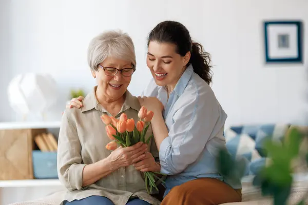 Mooie Jonge Vrouw Haar Moeder Met Bloemen Tulpen Handen Thuis — Stockfoto