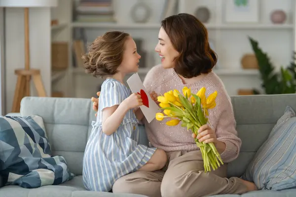 Glücklicher Muttertag Tochter Gratuliert Mama Und Schenkt Ihr Blumen Und lizenzfreie Stockbilder