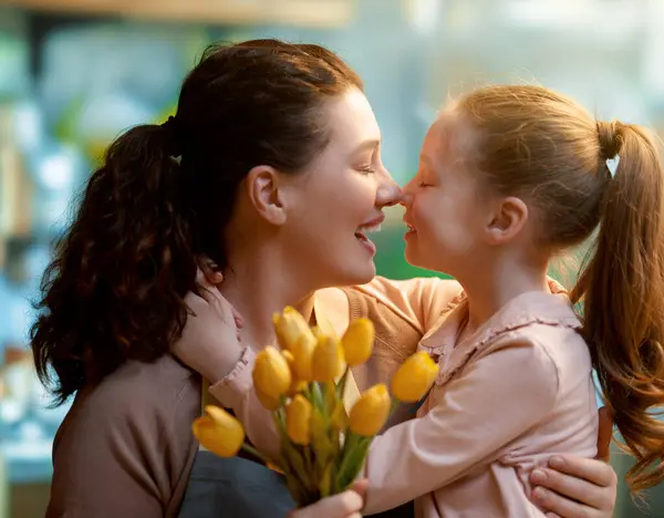 ハッピーマザーの日 子供の娘は母親を祝福し 花を与えています ママと少女は微笑み 抱きしめている 家族の休日とトータル ストック写真