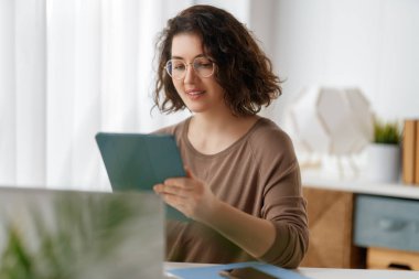 Ofiste dizüstü bilgisayarla çalışan mutlu, sıradan bir kadın..