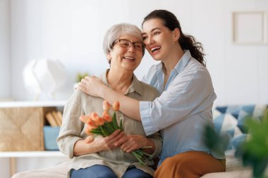Güzel genç bir kadın ve elinde çiçeklerle annesi ellerinde laleler..  