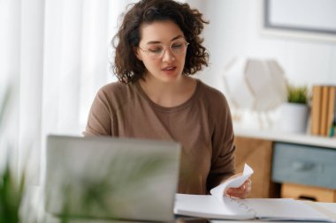 Ofiste dizüstü bilgisayarla çalışan mutlu, sıradan bir kadın..