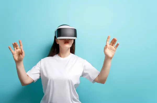元技术的概念 拥有Vr虚拟现实的女人在浅蓝色的墙壁背景上戴着护目镜 未来主义生活方式 图库图片