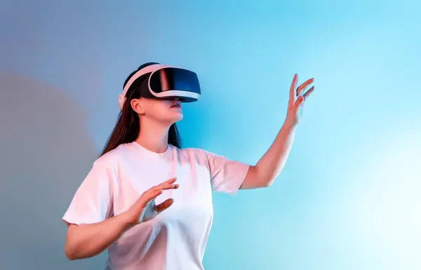 元技术的概念 拥有Vr虚拟现实的女人在浅蓝色的墙壁背景上戴着护目镜 未来主义生活方式 免版税图库照片