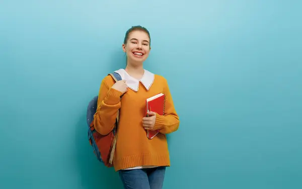 回到学校和快乐的时光 可爱勤劳的青少年在彩色纸墙的背景 背着背包的女孩准备学习的青少年 图库图片