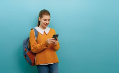 Okula ve mutlu zamanlara. Duvar kağıdının arka planında sevimli, çalışkan bir genç. Telefonu olan kız. Çalışmaya hazır gençler..