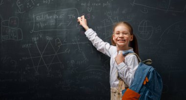 Okula dönelim. Mutlu şirin, çalışkan çocuk içeride. Çocuk sınıfta tahtada öğreniyor.. 