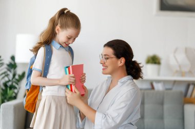 Mutlu aile okula hazırlanıyor. Annesi olan küçük bir kız..