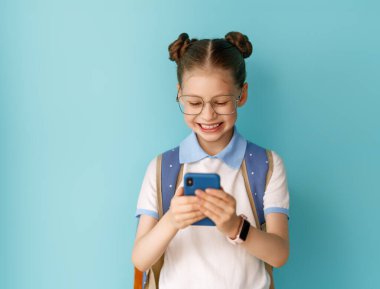 Okula ve mutlu zamanlara. Duvar kağıdının arka planında sevimli, çalışkan bir genç. Telefonu olan kız. Çalışmaya hazır gençler..