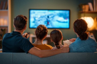 Mutlu aile birlikte vakit geçiriyor. Anne, baba ve çocuklar televizyon izliyor, akşamları evde patlamış mısırlı filmler izliyorlar..
