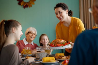 Şükran Günün kutlu olsun. Sonbahar ziyafeti. Aile masada oturup bayramı kutluyor. Büyükanne ve büyükbaba, anne ve çocuklar. Geleneksel yemek..