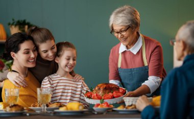 Şükran Günün kutlu olsun. Sonbahar ziyafeti. Aile masada oturup bayramı kutluyor. Büyükanne ve büyükbaba, anne ve çocuklar. Geleneksel yemek..
