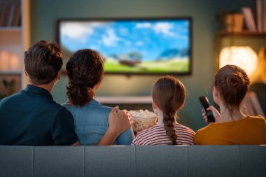 Mutlu aile birlikte vakit geçiriyor. Anne, baba ve çocuklar televizyon izliyor, akşamları evde patlamış mısırlı filmler izliyorlar..