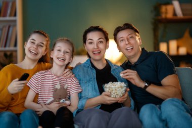 Mutlu aile birlikte. Anne, baba ve çocukları video oyunu oynuyorlar. İnsanlar evde eğleniyor..