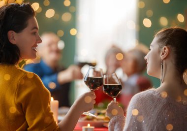 Mutlu noeller. Mutlu aile evde yemek yiyor. Kutlama tatili ve ağacın yakınındaki birliktelik.