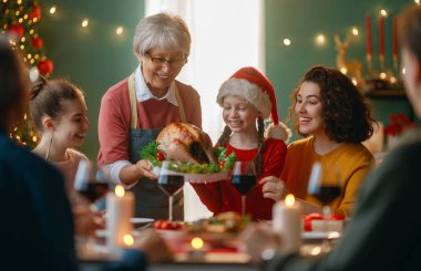 Mutlu noeller. Mutlu aile evde yemek yiyor. Kutlama tatili ve ağacın yakınındaki birliktelik.