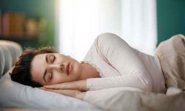 Güzel genç bir kadın evdeki yatak odasında uyuyor..