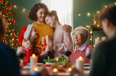 Mutlu noeller. Mutlu aile evde yemek yiyor. Kutlama tatili ve ağacın yakınındaki birliktelik.