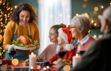 Mutlu noeller. Mutlu aile evde yemek yiyor. Kutlama tatili ve ağacın yakınındaki birliktelik.