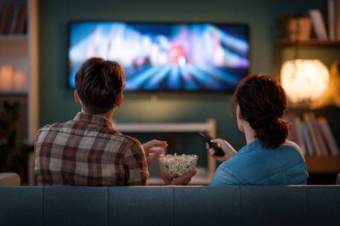Mutlu bir aile televizyon seyrediyor, akşamları evde film seyrediyor. Çiftler birlikte vakit geçiriyorlar..