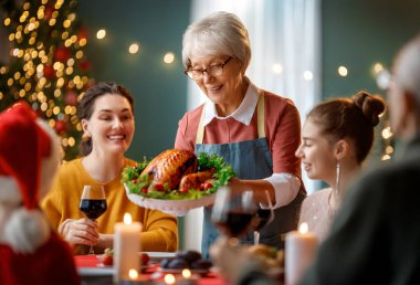 Mutlu noeller. Mutlu aile evde yemek yiyor. Kutlama tatili ve ağacın yakınındaki birliktelik.